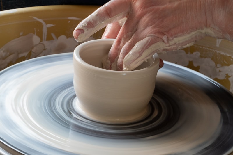 A pot being thrown on the wheel in the studio
